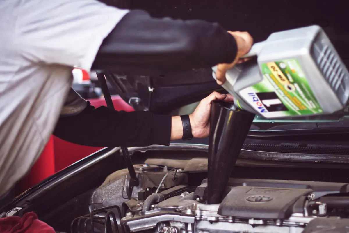 Image illustrating the concept of auto credit, a person signing a loan contract for a car.